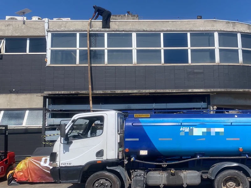 Mangueira de caminhão pipa enchendo uma cisterna